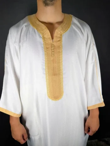 Mise en avant sur la broderie dorée au centre d’une gandoura blanche pour homme