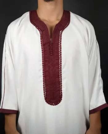 Mise en avant sur la broderie bordeaux au centre d’une gandoura blanche pour homme